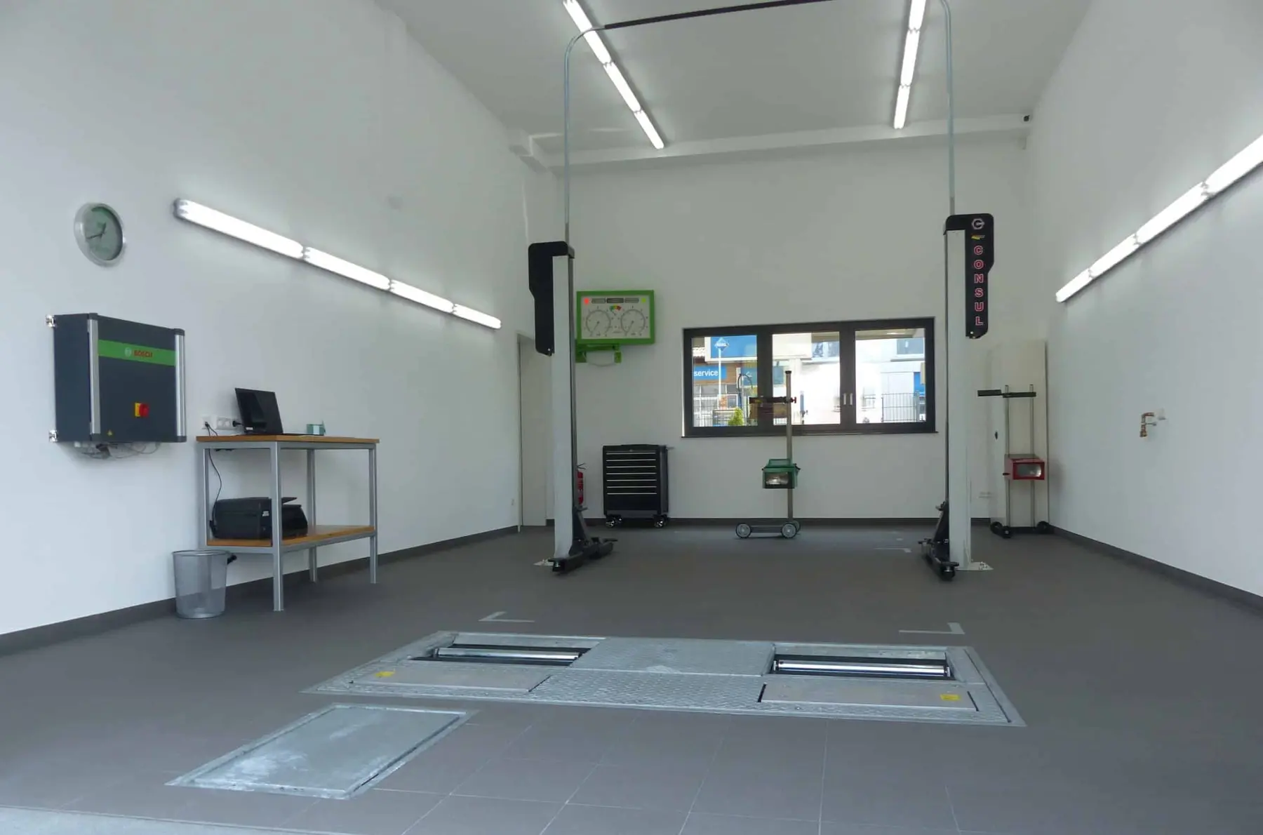 Helle Prüfhalle mit Zwei-Säulen-Hebebühne und Arbeitsplatz